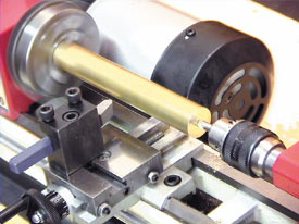 センタードリル(オプション)を用いて、素材の両端にセンター穴を開けます。この様に材料の端面にセンター穴をあけ、センターで押し支える事で心を出し、加工時のブレ等を抑えます。